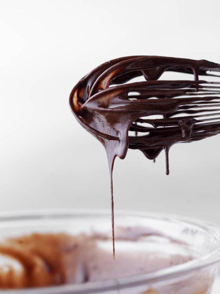 chocolate cake batter dripping of a whisk