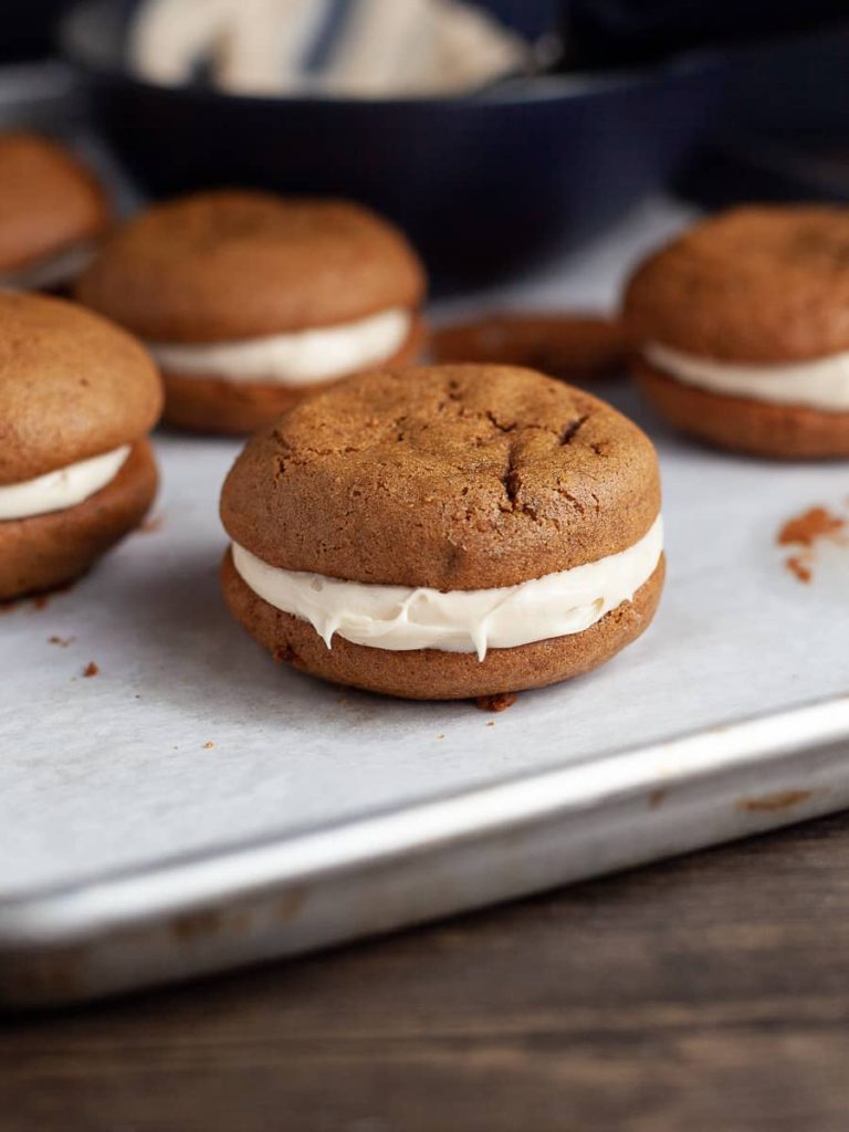 Gluten Free Gingerbread Whoopie Pies are two perfectly spiced, soft gingerbread cookies sandwiched together with a luscious brown sugar frosting. The cake-like cookies are full of warm winter spices with a melt-in-your-mouth texture.