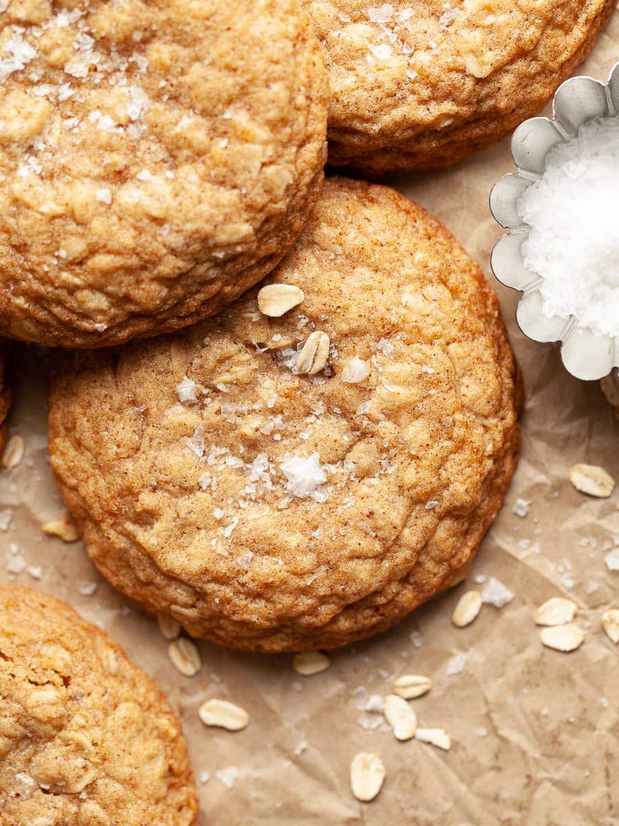 gluten free brown butter oatmeal cookies on brown parchment paper with flaky sea salt