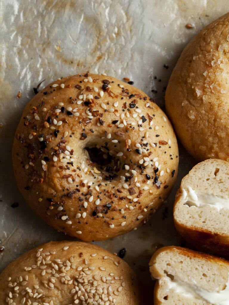 gluten free bagel with everything but the bagel seasoning on greasy parchment paper, gluten-free bagels 