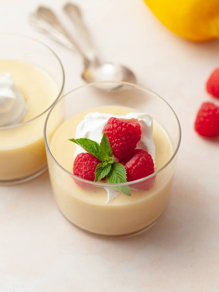lemon pudding with whipped cream and fresh raspberries