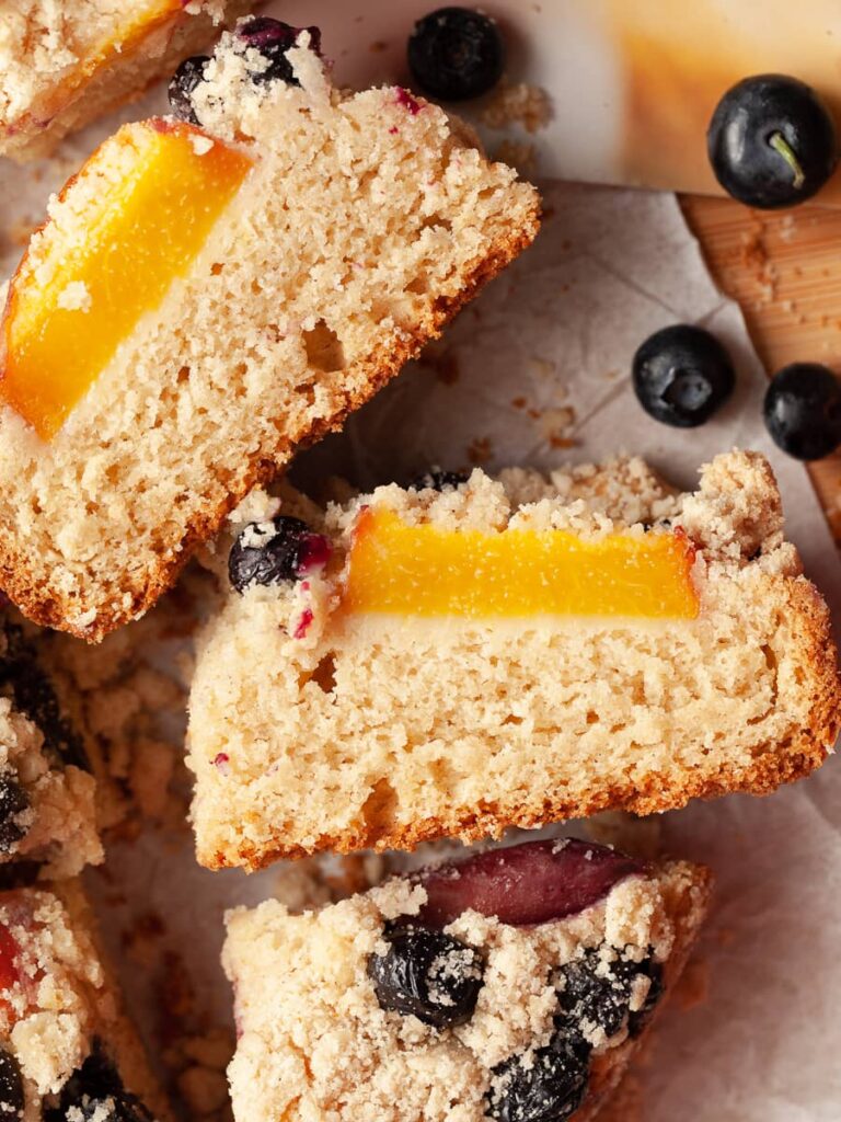 sliced gluten free coffee cake made with peaches and blueberries