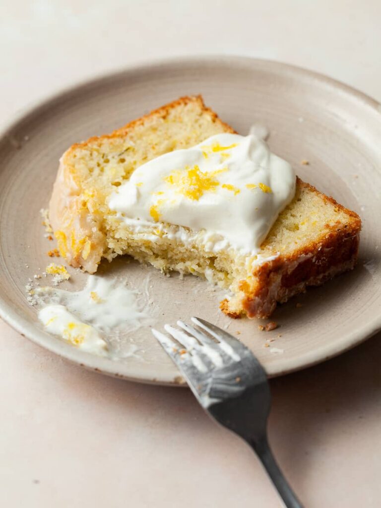 a slice of gluten free lemon zucchini cake on a plate with sour cream
