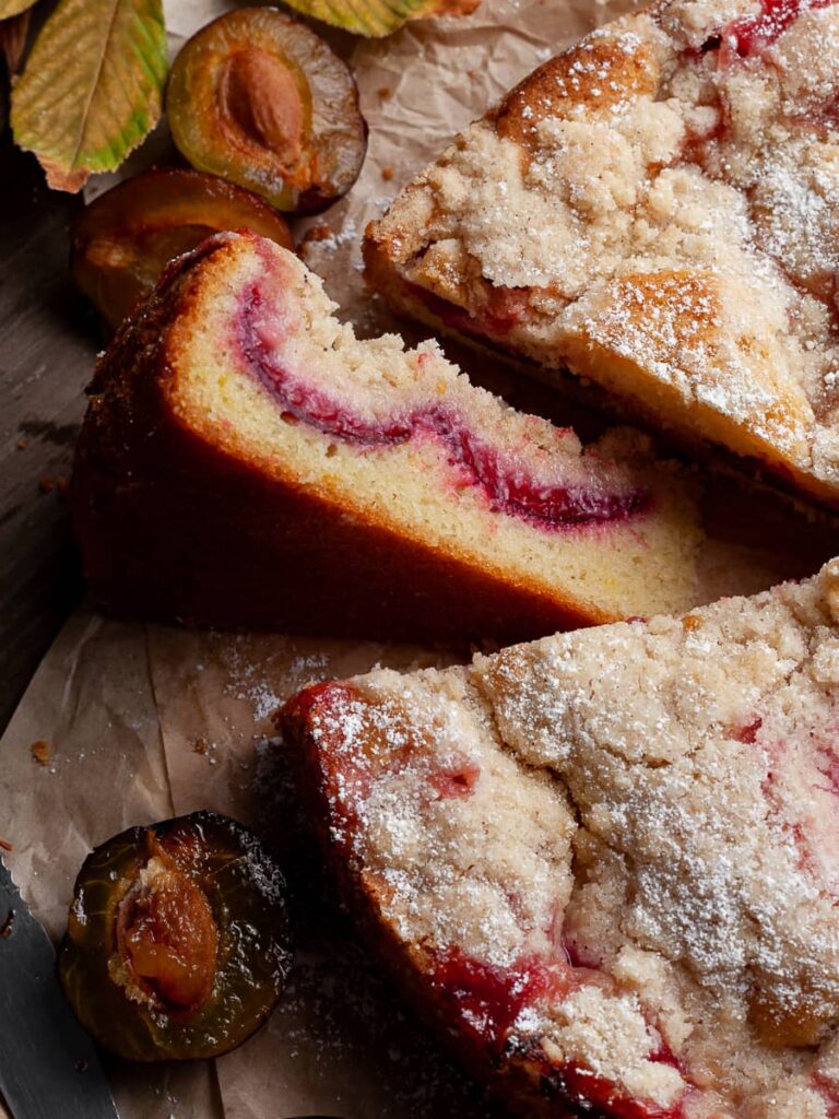 a slice plum cake on the side with the sliced plums showing