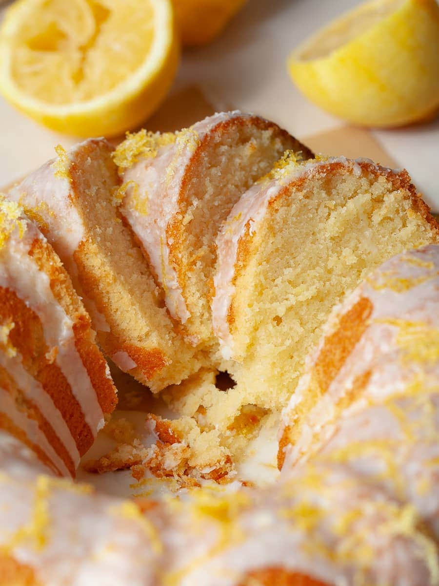 sliced gluten free lemon bundt cake topped wih lemon icing