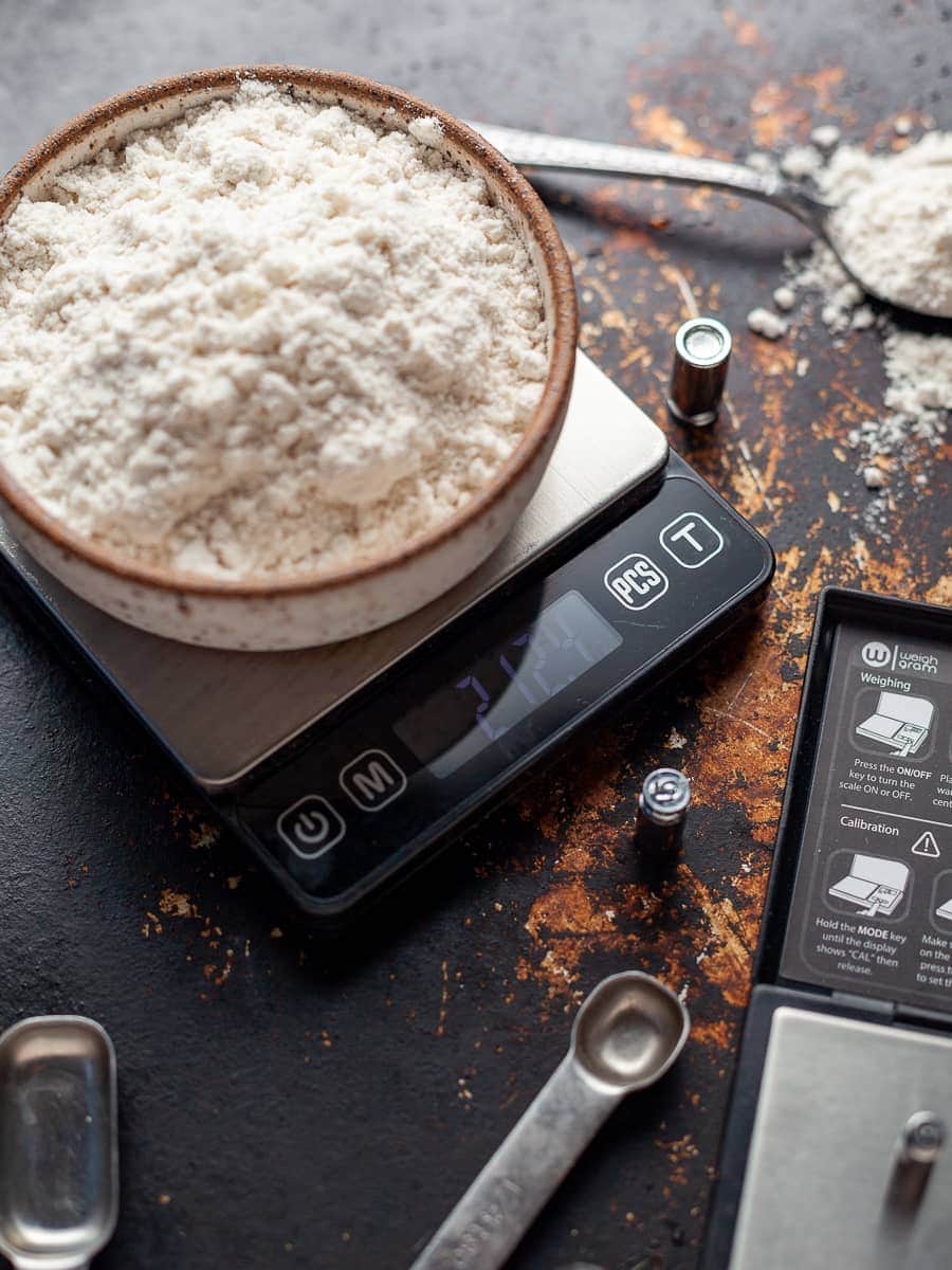 A sleek silver digital kitchen scale with a clear and easy-to-read display, measuring ingredients in grams and ounces on a flat platform.