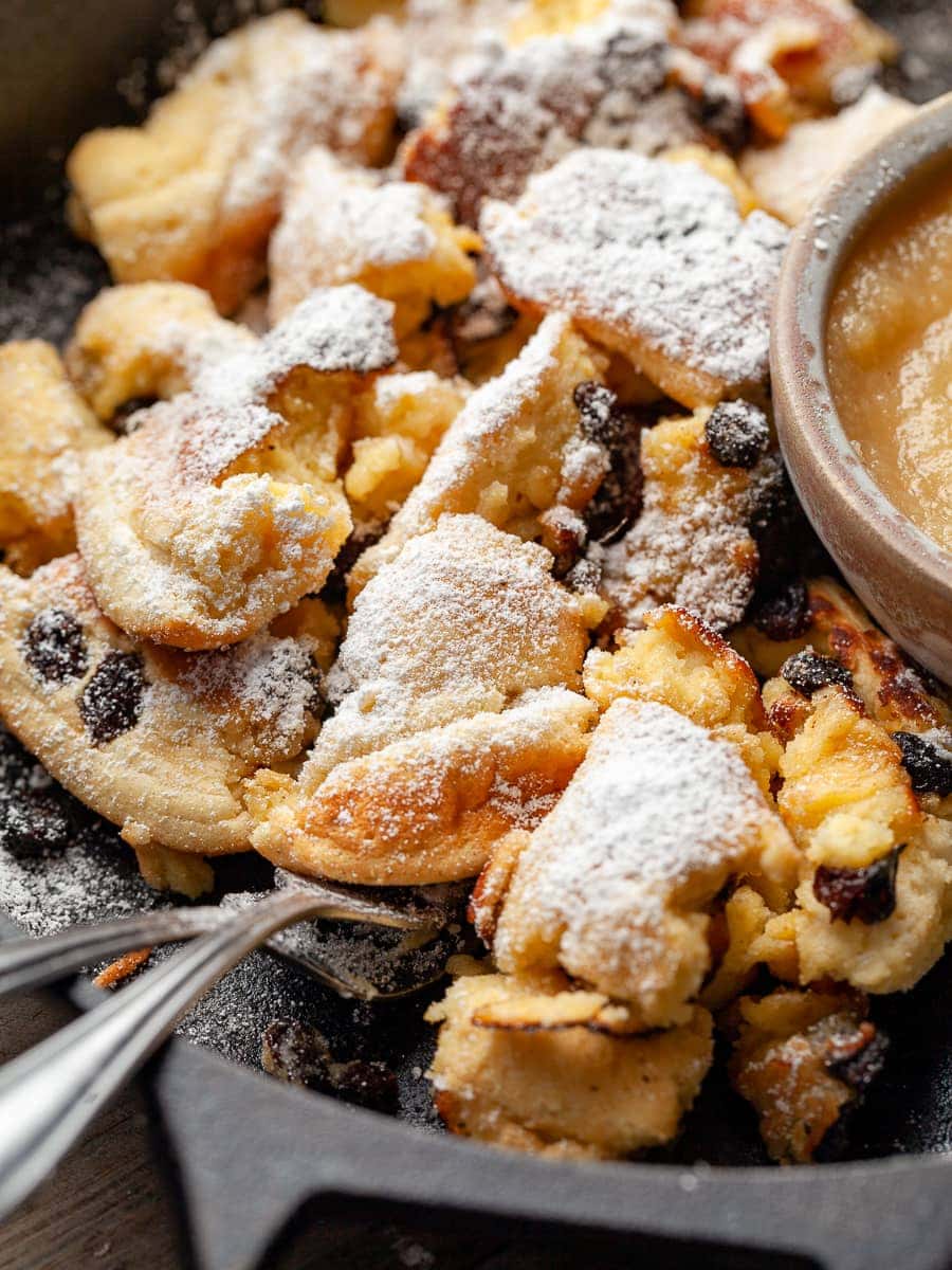 Kaiserschmarrn in a cast iron skillet dusted with powdered sugar