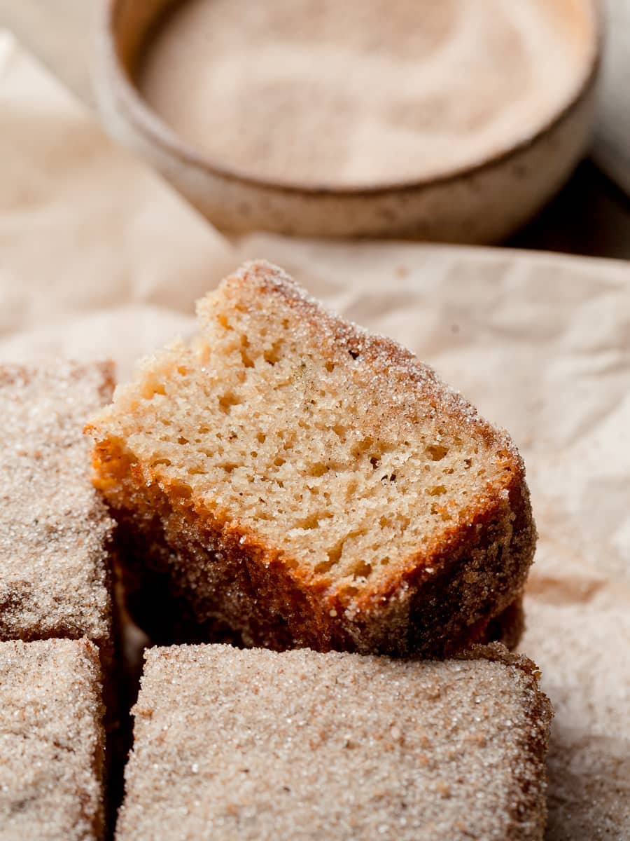 a slice of gluten free apple cider cake on brown parchment paper