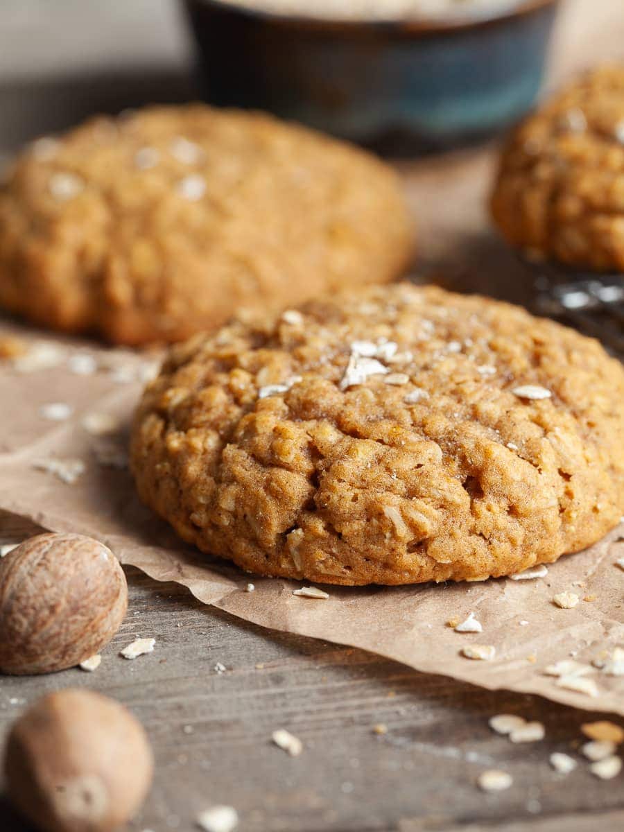 Gluten Free Pumpkin Oatmeal Cookies on a brown parchment paper topped with instant oats