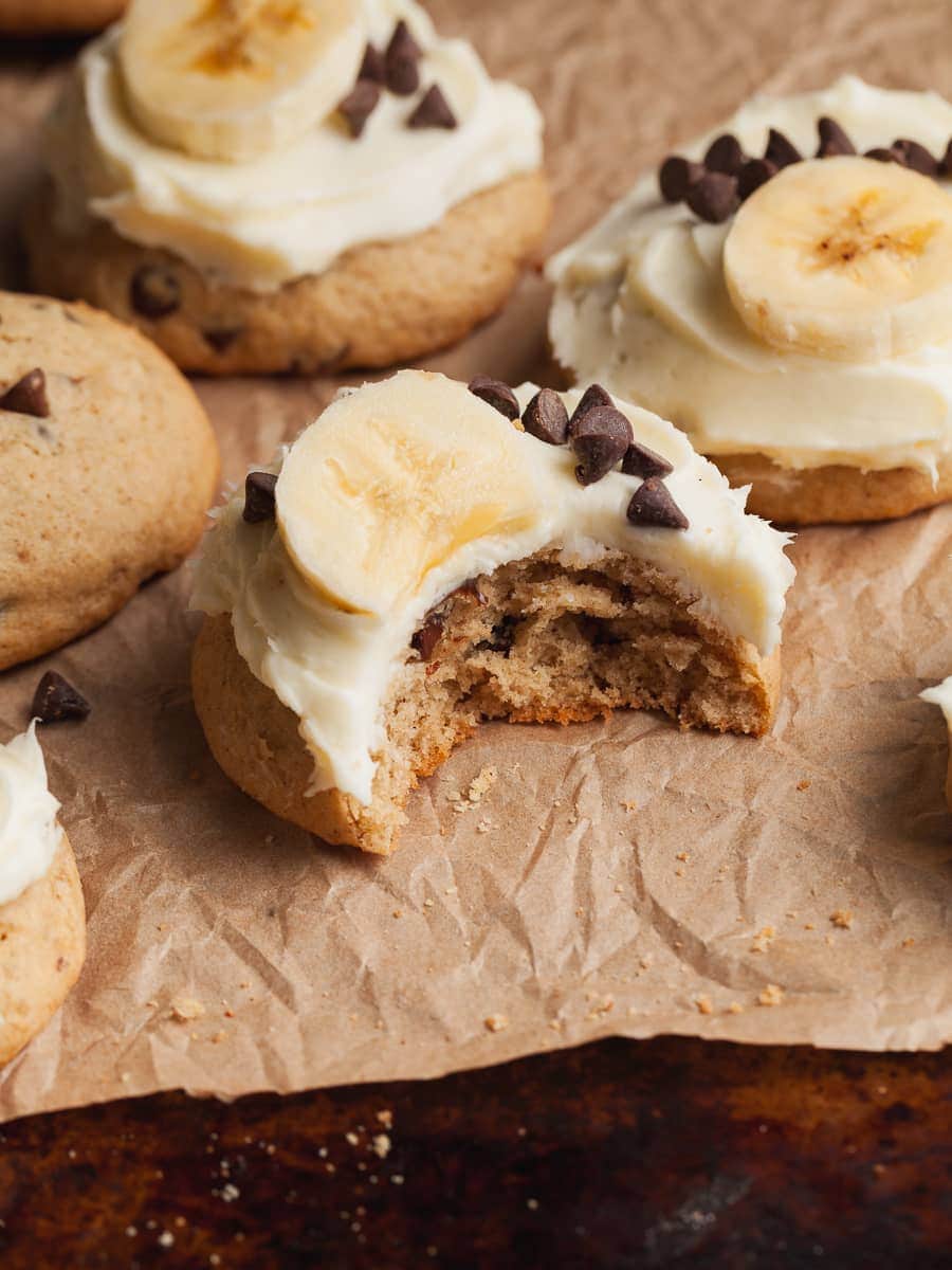gluten free banana cookies with cream cheese frosting. topped with mini chocolate chips and fresh sliced bananas
