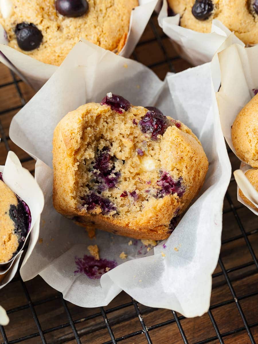 sourdough discard muffins with blueberries and white chocolate in white muffin papers in a muffin tin