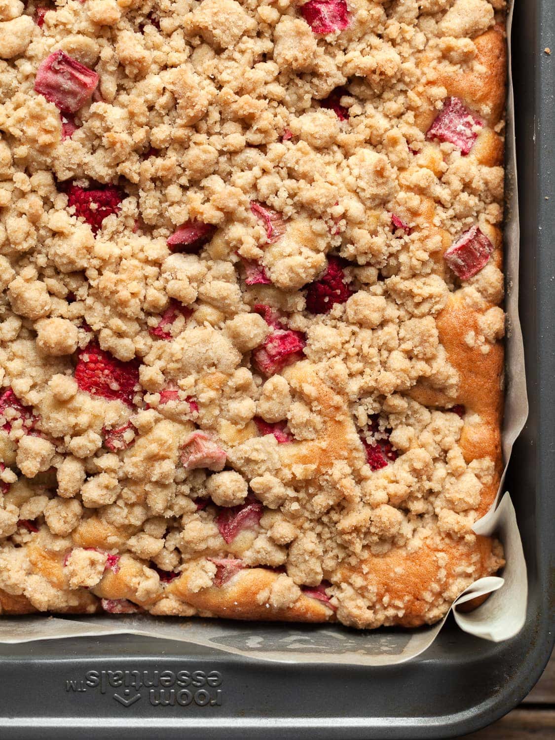 a close up of gluten free rhubarb coffee cake topped with a brown sugar streusel in a baking pan