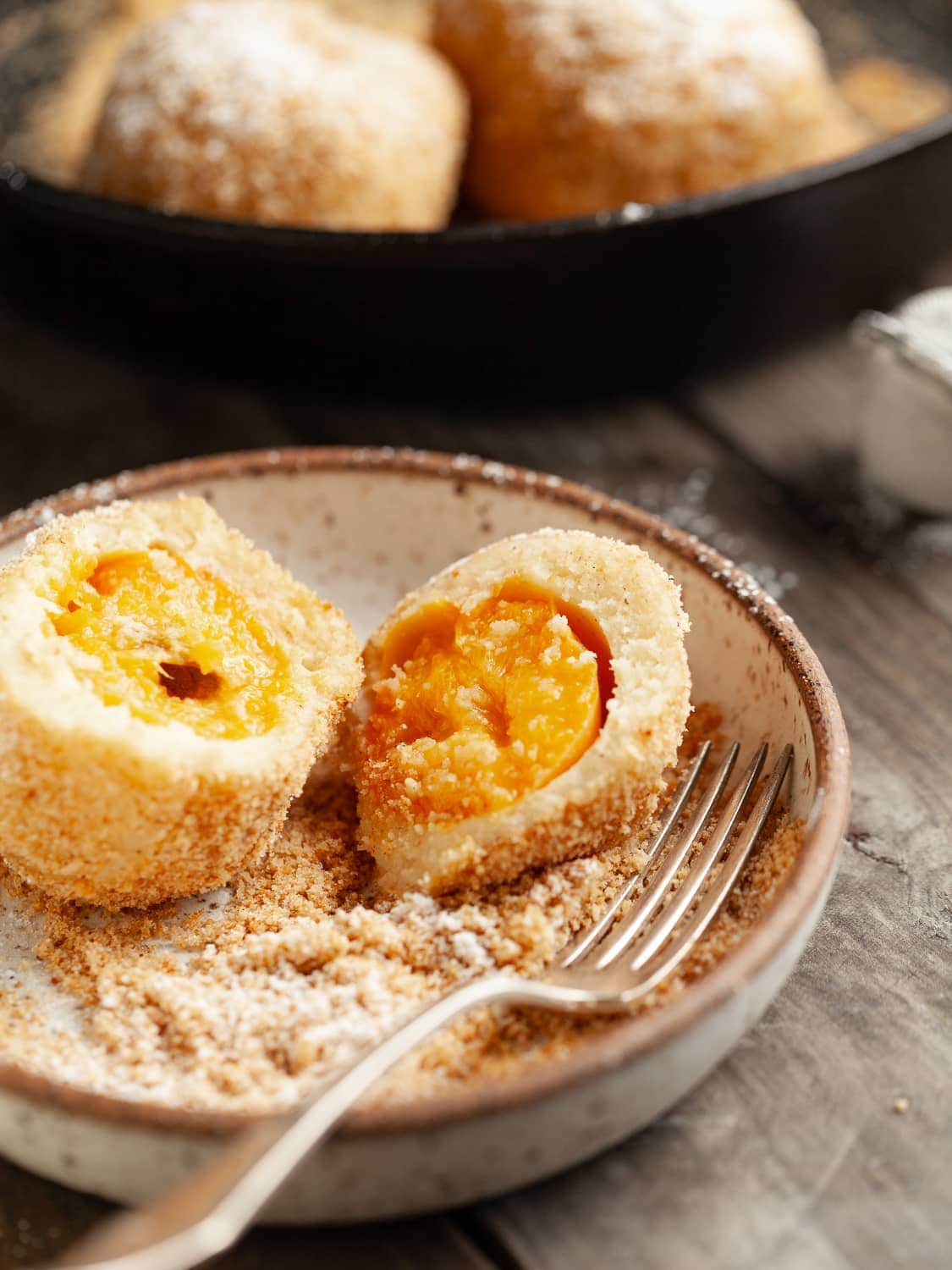 Split open Gluten Free Marillenknödel (Austrian Apricot Dumplings) in a plate