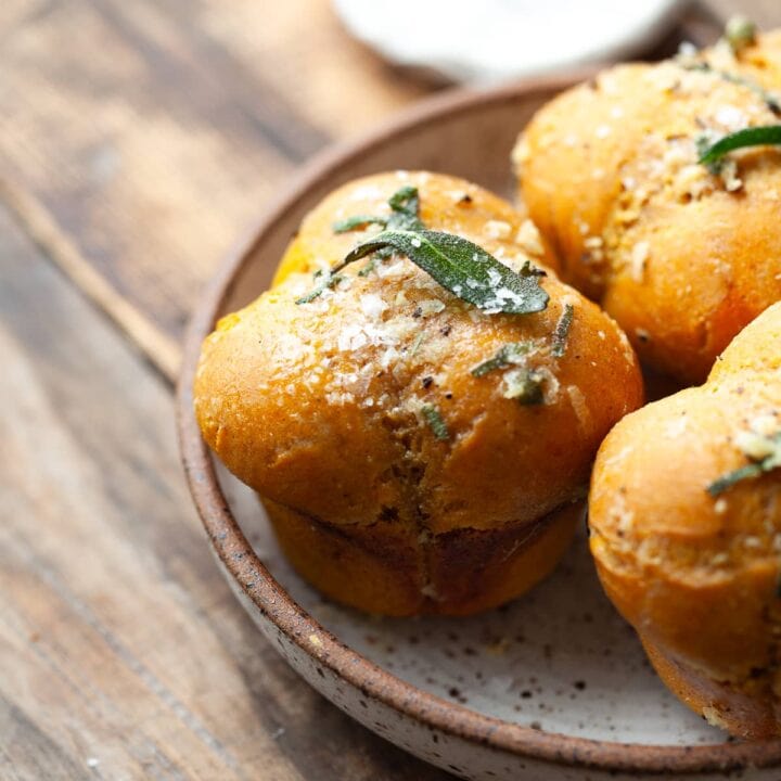 Soft, fluffy gluten free pumpkin dinner rolls with sage garlic butter—perfect for Thanksgiving and cozy fall meals. Easy to make and packed with cozy flavor!