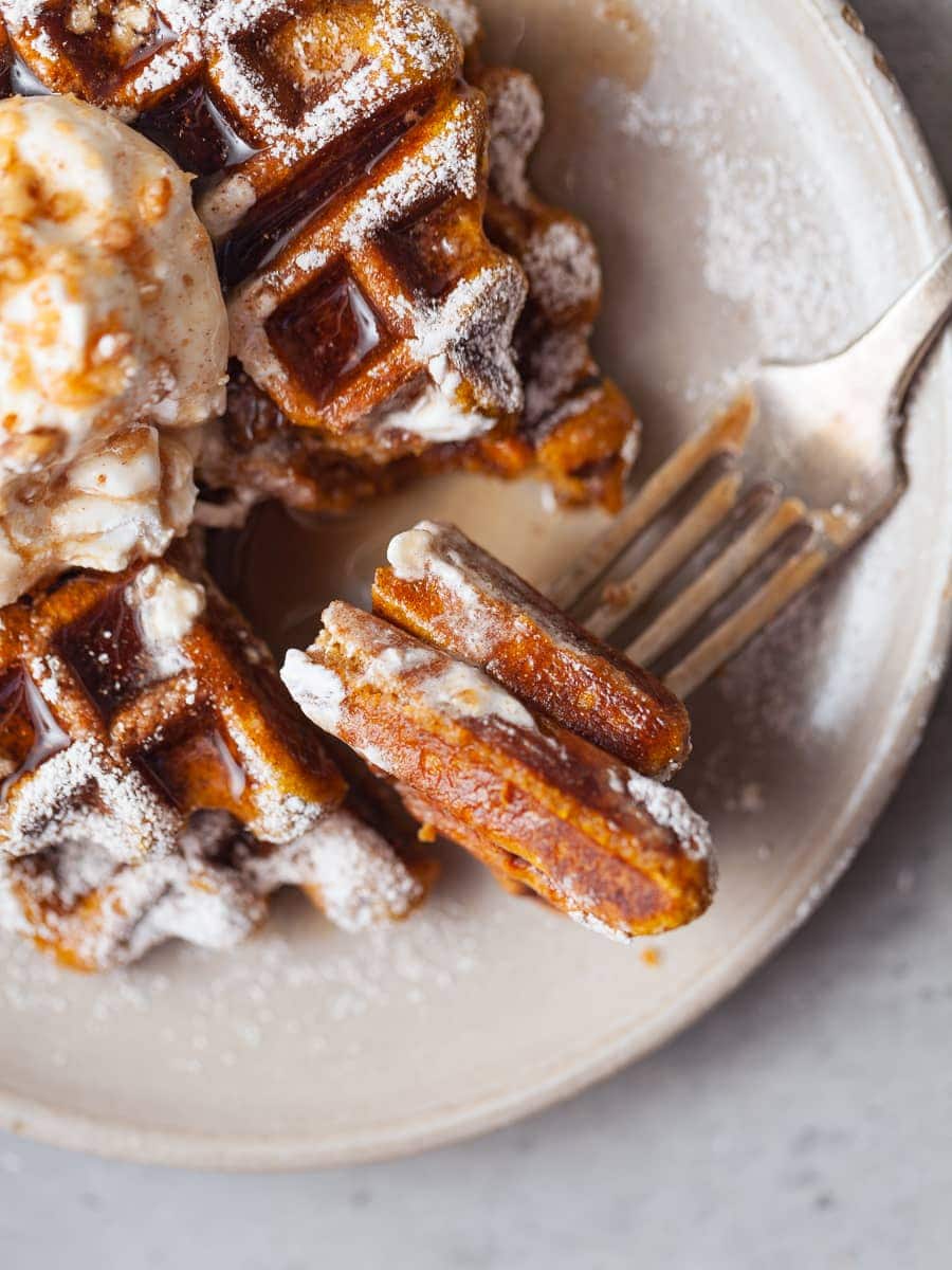 a close up of a bite of pumpkin waffles on a fork