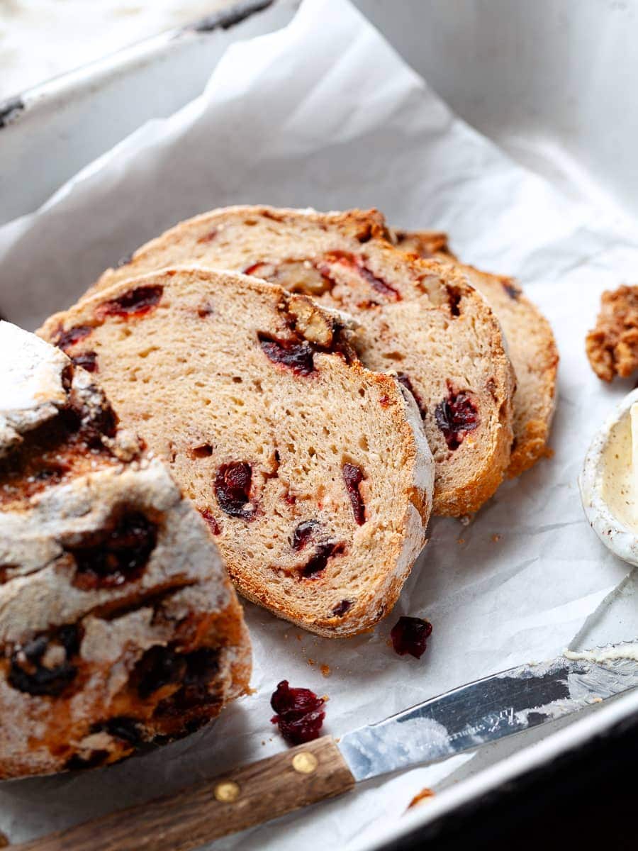 slices of gluten free cranberry walnut bread on parchment paper