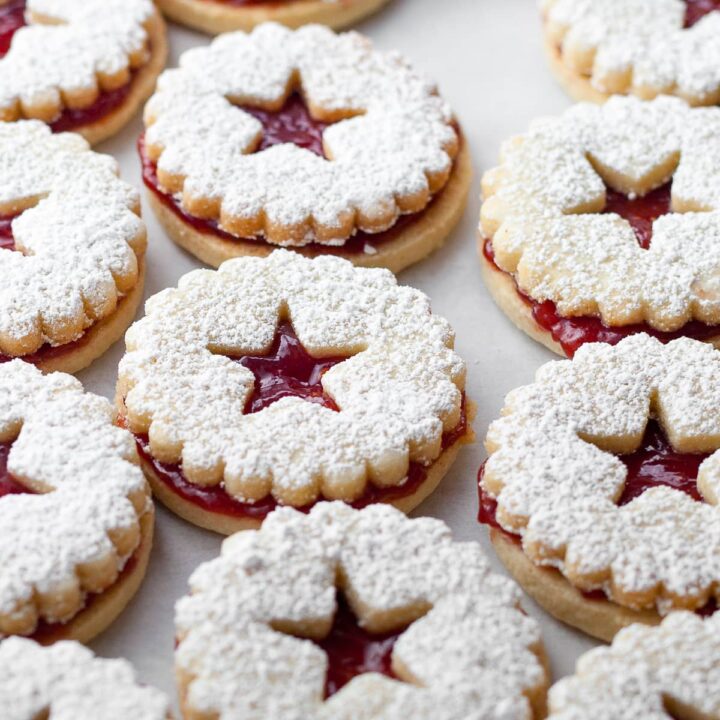 traditional austrian linzer cookies made with gluten free ingredients, cut out, with little stars in the center and dusted with powdered sugar