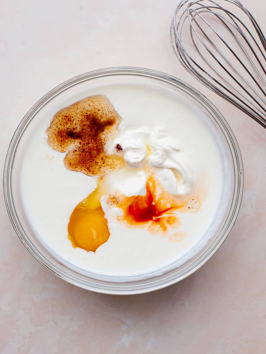 buttermilk, egg, sourcream, hot sauce and bacon grease in a bowl with a whisk