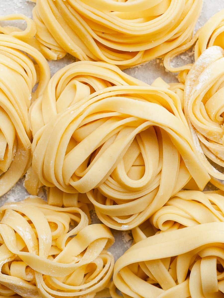 gluten free fresh pasta cut into fettucine and arranged in little twirls on a lightly floured parchment paper