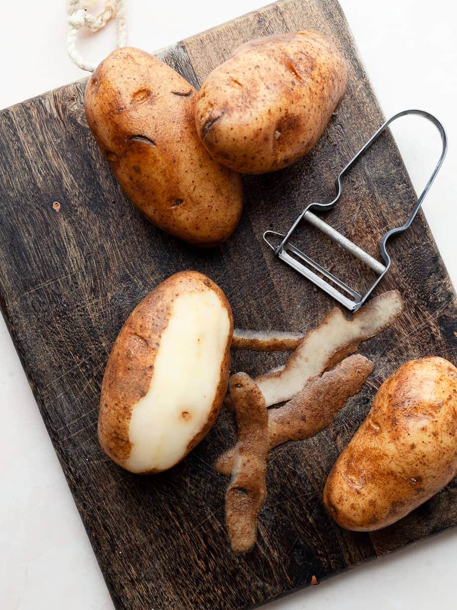 peeled potatoes on a cutting board