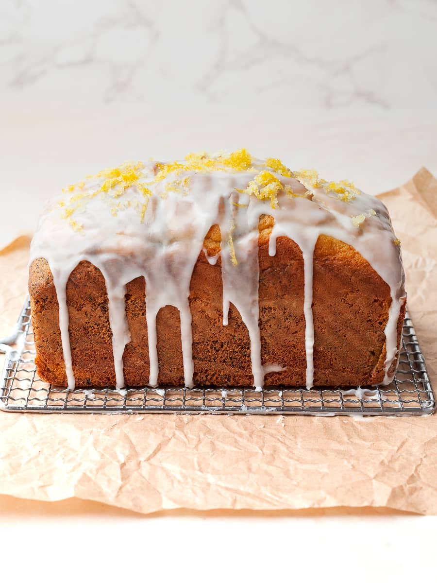 a glazed lemon poppy seed loaf on a cooling rack