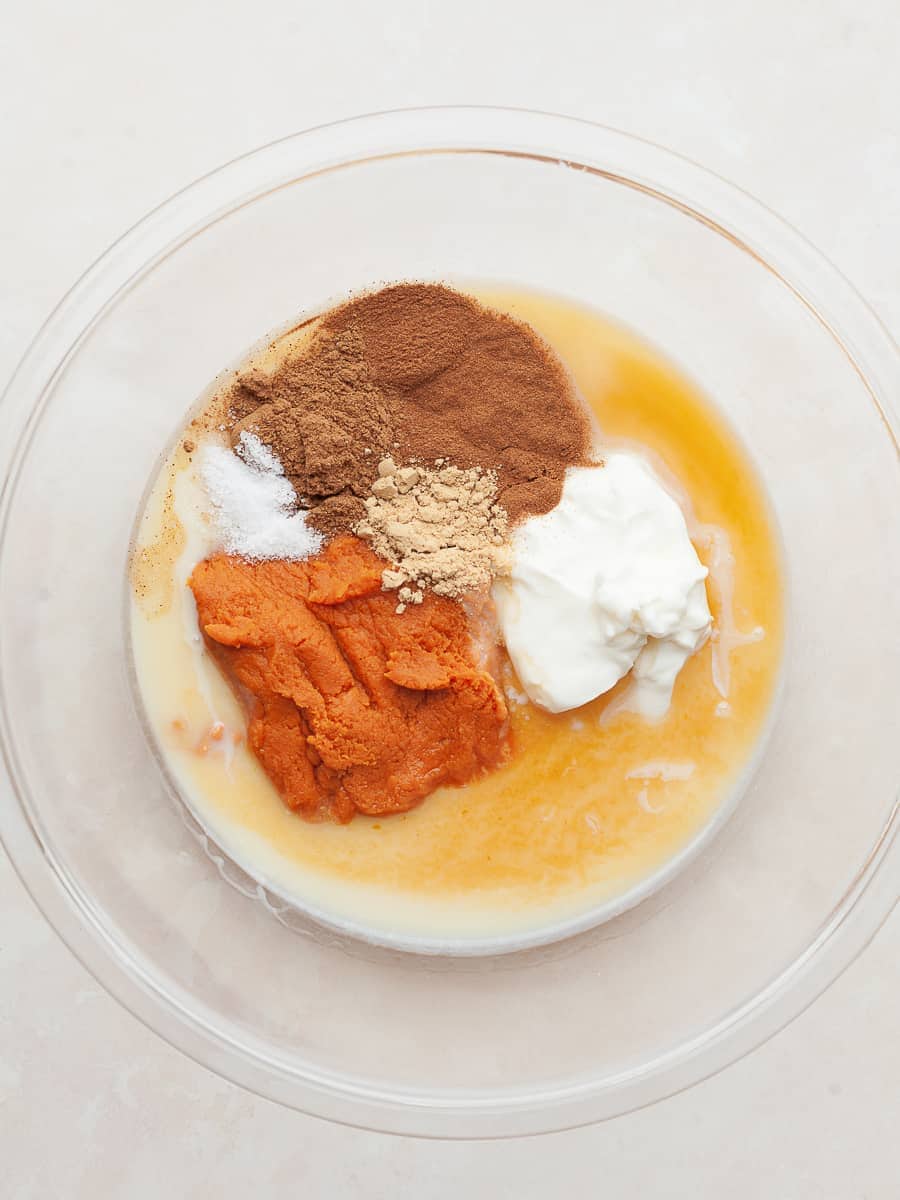 a bowl with condensed milk, pumpkin, sour cream and spices to make no churn pumpkin ice cream