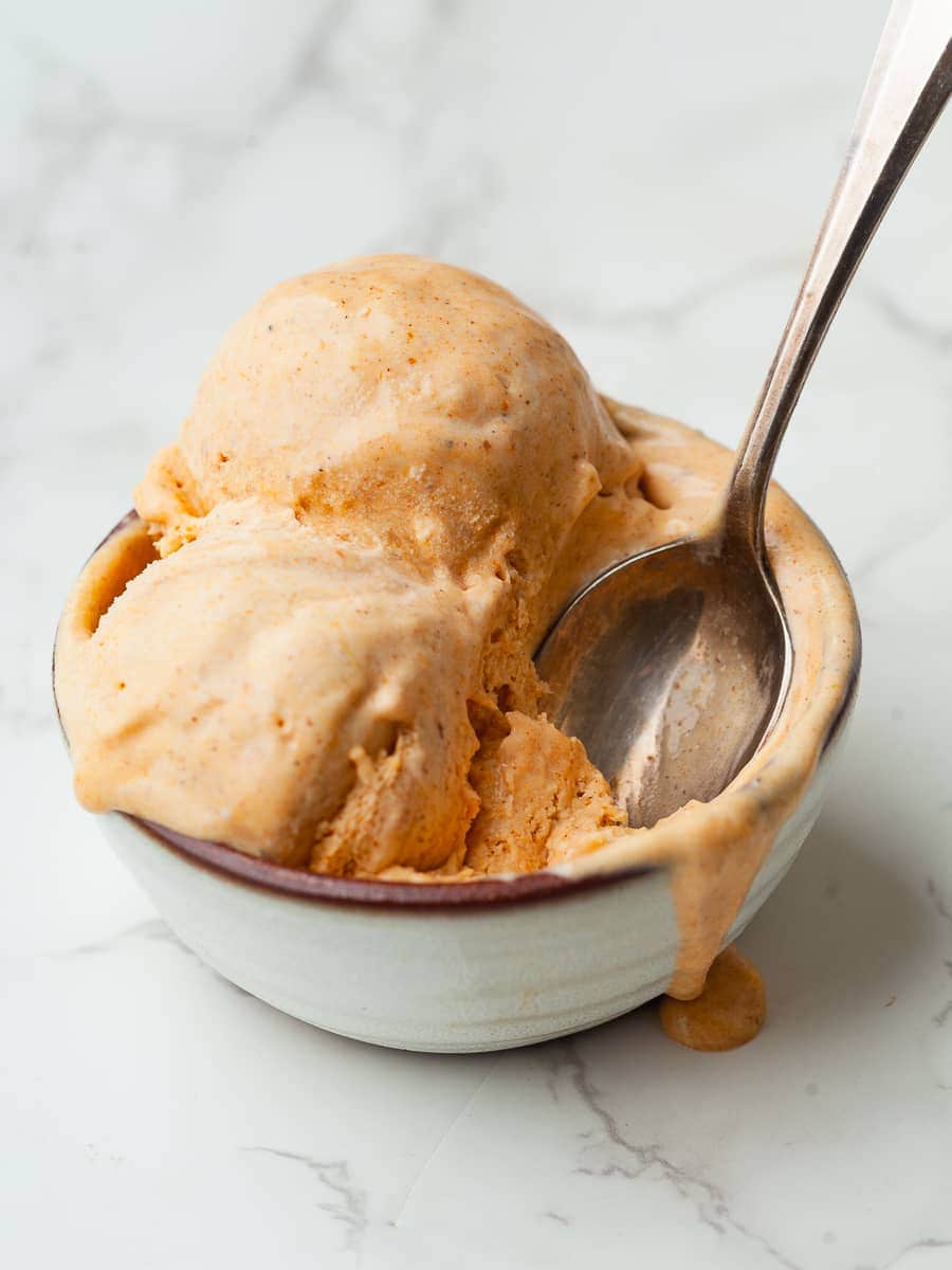 a bowl of gluten free no churn pumpkin ice cream with a spoon