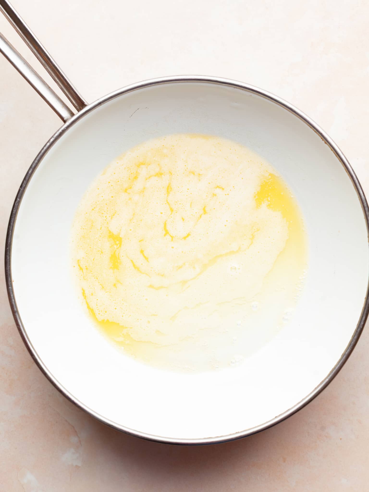melted butter in a white sautee pan